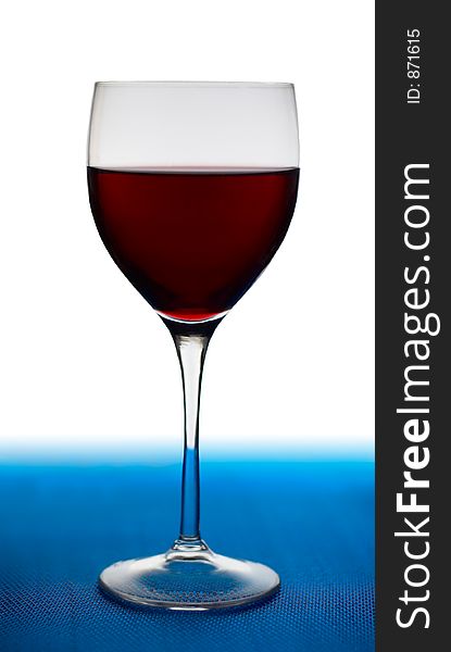 A glass of red wine on blue