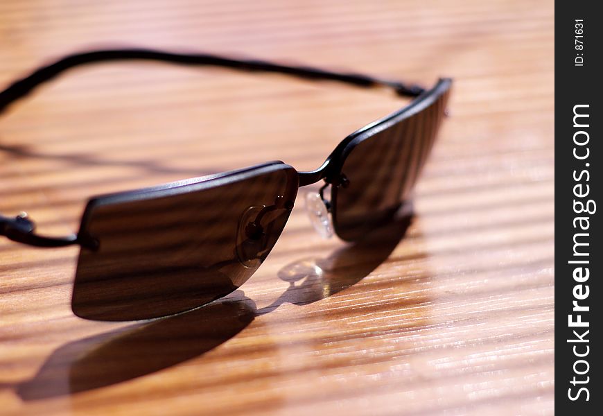 Mens' sunglasses in strong light and shadow in very shallow focus. Mens' sunglasses in strong light and shadow in very shallow focus.