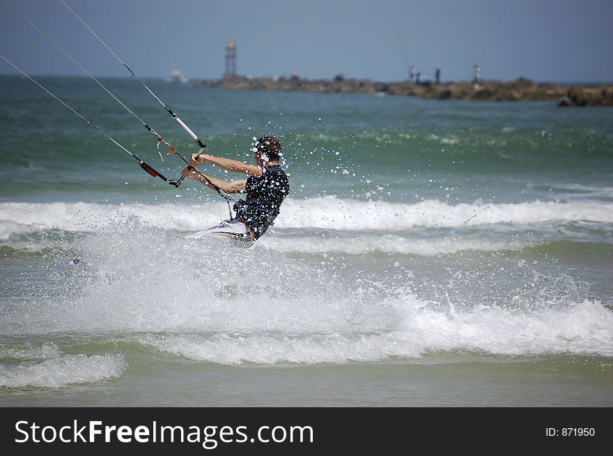 A kitesurfer churns up the surf as he turns the corner at Ponce Inlet Beach, Florida. A kitesurfer churns up the surf as he turns the corner at Ponce Inlet Beach, Florida