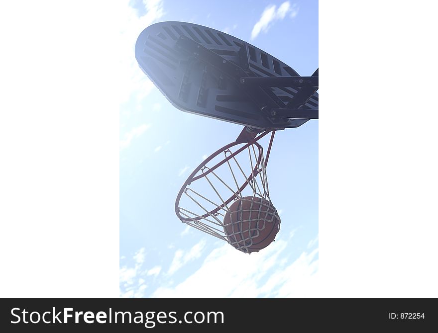 Basketball is hung waiting to be dropped through the hoop. Basketball is hung waiting to be dropped through the hoop