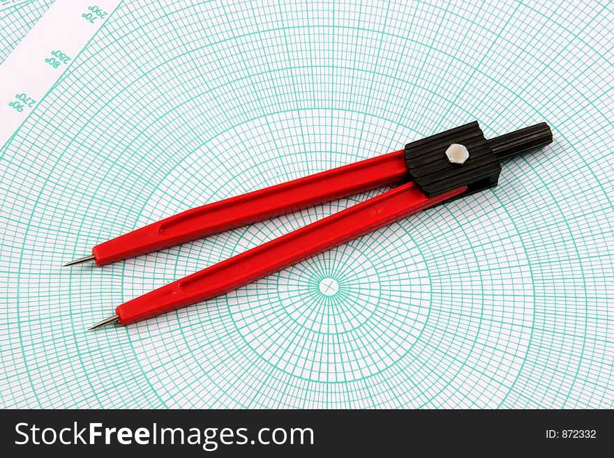 Red compass over a polar graphic paper. Red compass over a polar graphic paper