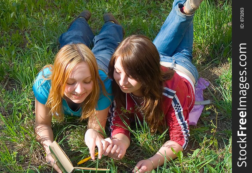 Girlfriends read book lying down. Girlfriends read book lying down