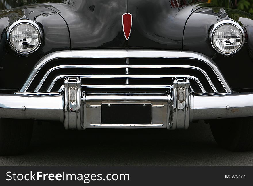 Photograph of an old classic car in mint condition, shining chrome and highly polished finish , almost like a face with mouth eyes and nose. Photograph of an old classic car in mint condition, shining chrome and highly polished finish , almost like a face with mouth eyes and nose