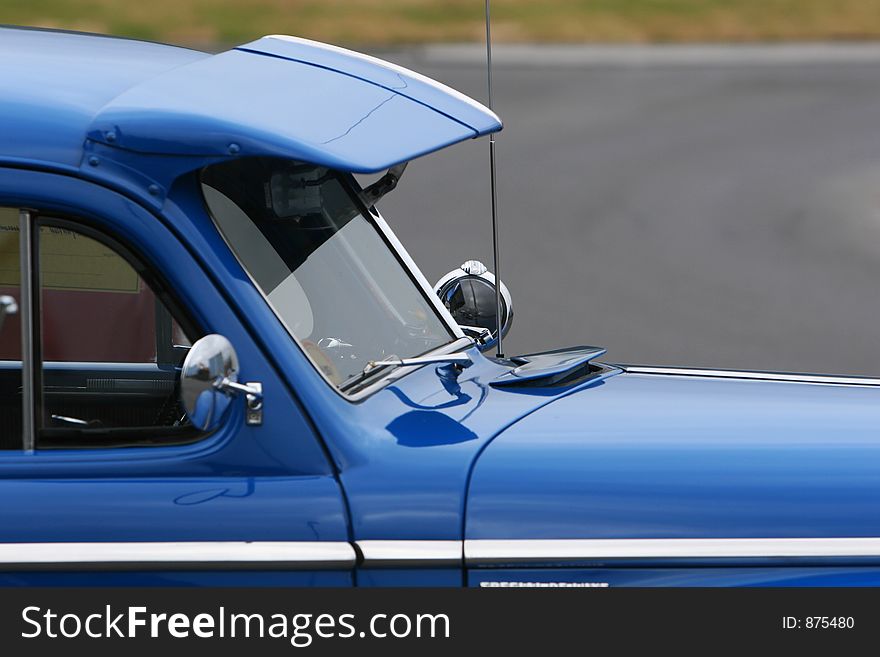 Photograph of an old classic car in mint condition, shining chrome and highly polished finish , front side, cropped shot. Photograph of an old classic car in mint condition, shining chrome and highly polished finish , front side, cropped shot