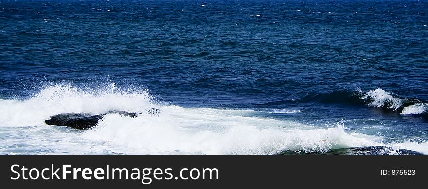 Panorama of the sea with wave on a rock