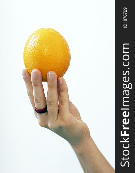 A woman's hand holding an orange. A woman's hand holding an orange.