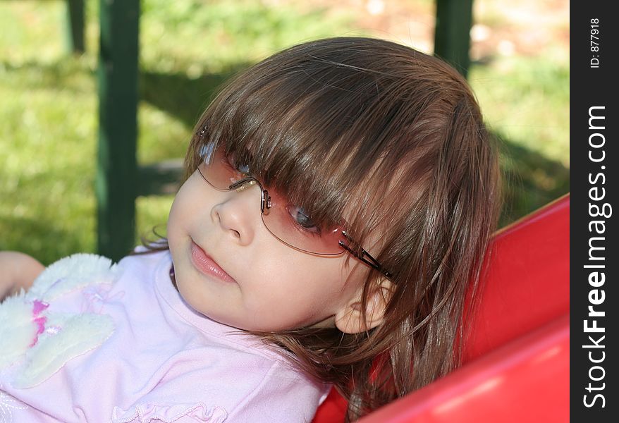 Small child playing outside while wearing sunglasses. Small child playing outside while wearing sunglasses