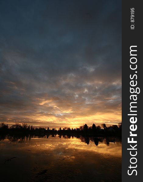 Sunset over a lake in the summer in the countryside  in denmark
 a lake in denmark at sunset. Sunset over a lake in the summer in the countryside  in denmark
 a lake in denmark at sunset