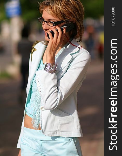 Young woman walking on the street and talking on the phone
