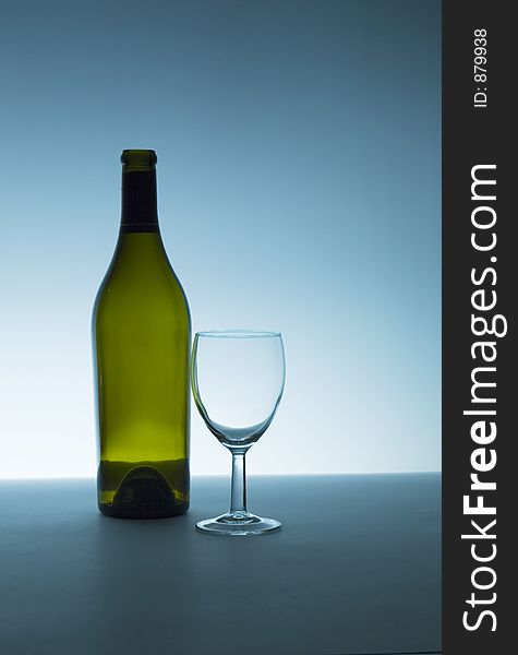 Wine bottle and glass, both are empty. Backlight with small amount of fill. Wine bottle and glass, both are empty. Backlight with small amount of fill.