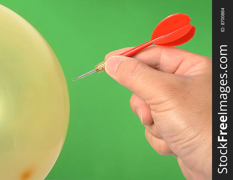 Hand dart punctured balloon,Green background. Hand dart punctured balloon,Green background