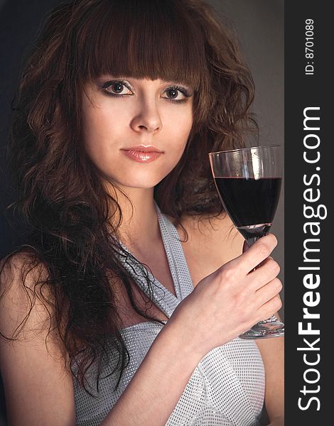 Beautiful girl with a wineglass on a black background