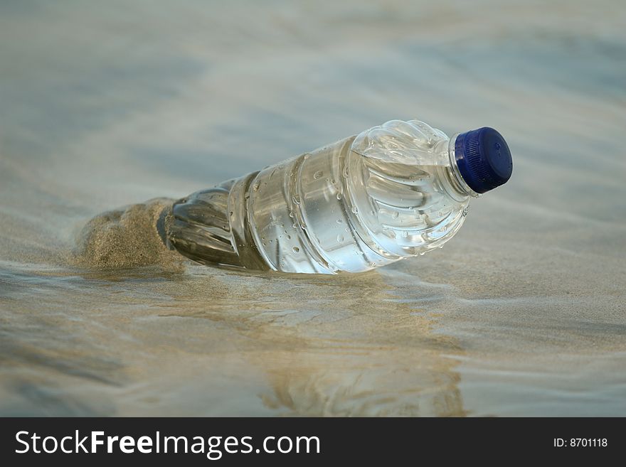 Plastic bottle in water on the sand beach. Plastic bottle in water on the sand beach