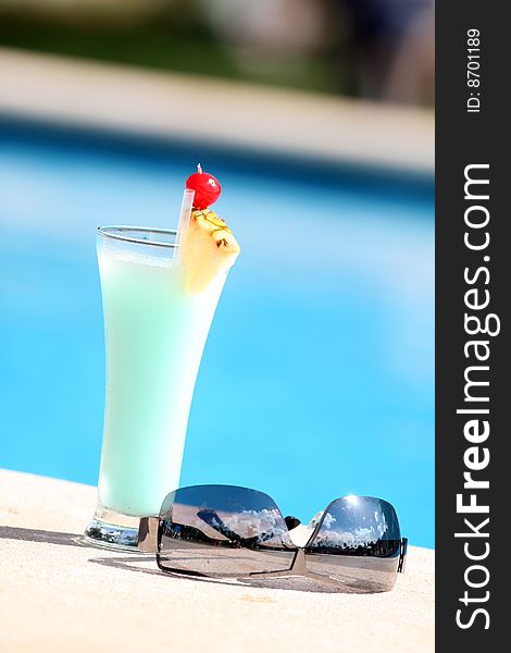 Cocktail with sunglasses on the edge of the swimming pool. Cocktail with sunglasses on the edge of the swimming pool