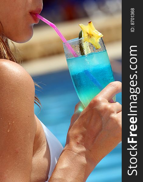 Woman drinking fresh cocktail by the swimming pool. Woman drinking fresh cocktail by the swimming pool