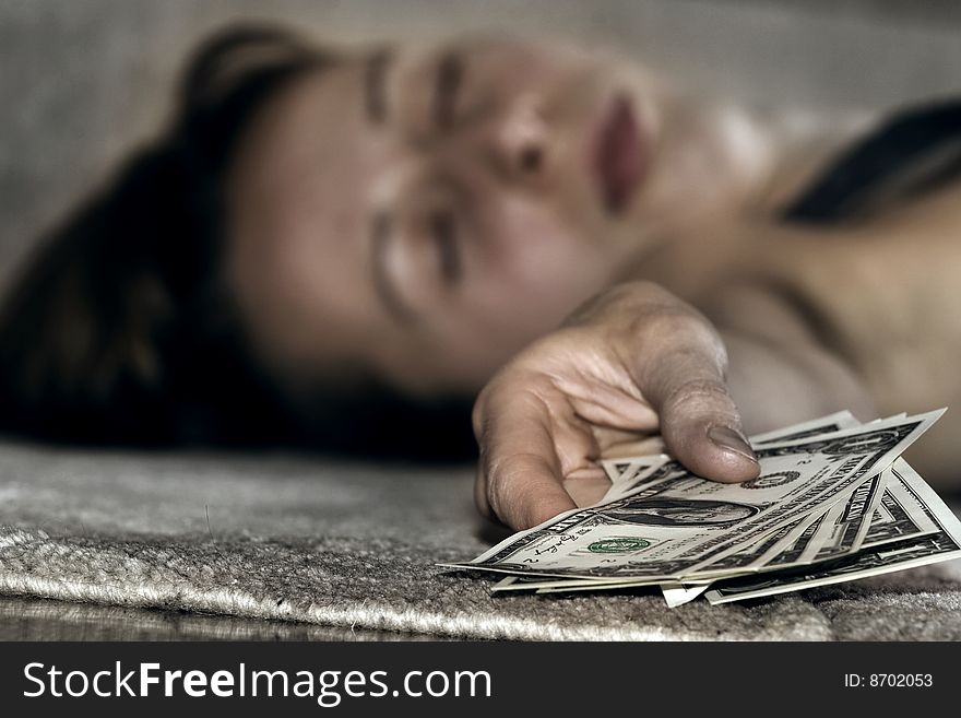 Unconscious woman lying on the floor holding money. Unconscious woman lying on the floor holding money