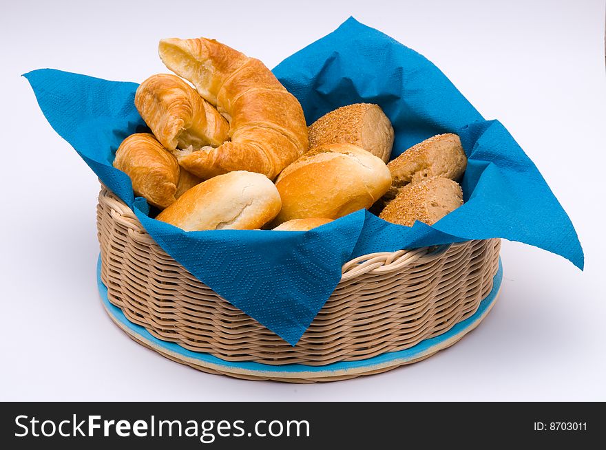 A basket with fresh baked bun and croissants. A basket with fresh baked bun and croissants.