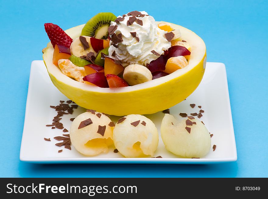 Some fresh fruits in a honeydew with cream and chocloate chips