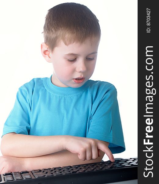 Young boy using a keyboard. Young boy using a keyboard