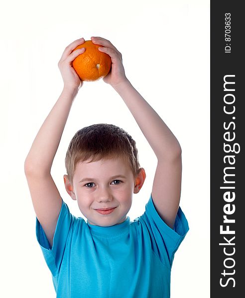 The little boy holds an orange in hands. The little boy holds an orange in hands