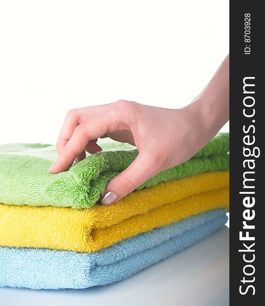 Three terry multi-coloured towels on a table