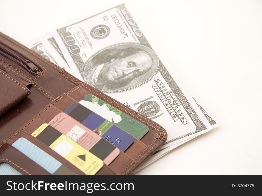 Fine leather wallet with credit cards inside and dollar bank notes isolated over white background, money concept.
