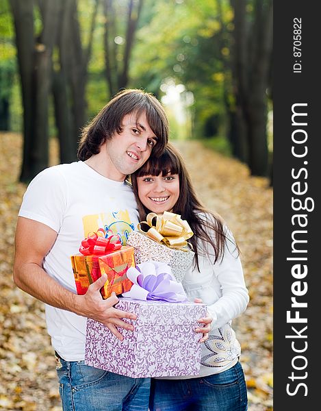 Young couple with gift boxes outside