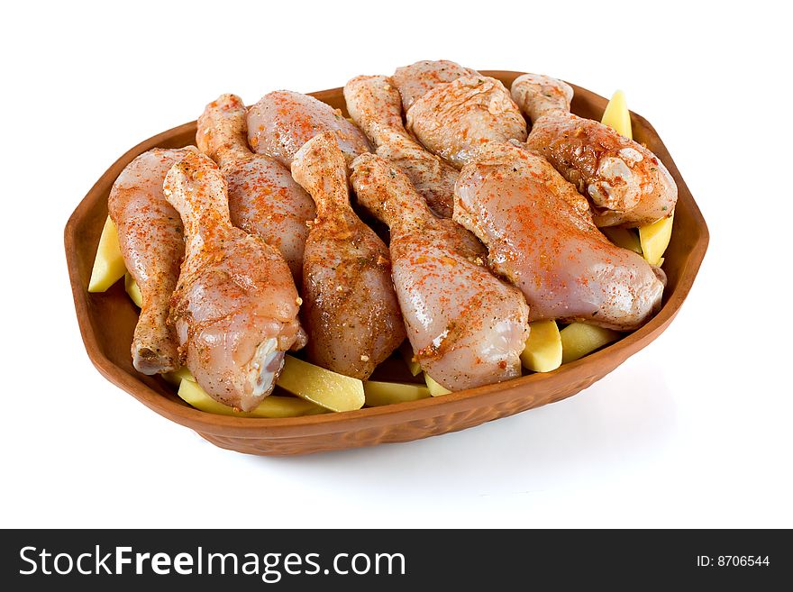 Raw chicken legs and potato in ceramic dish. Raw chicken legs and potato in ceramic dish