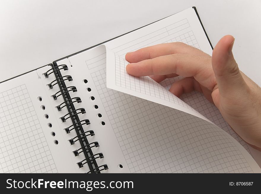 Hand turning page of blank spiral notebook (white background)