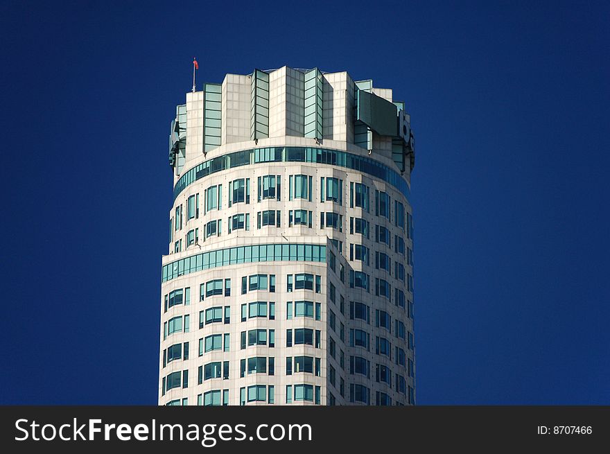 A modern high rise office building in a busy downtown area with a helicopter landing pad on the roof. A modern high rise office building in a busy downtown area with a helicopter landing pad on the roof.