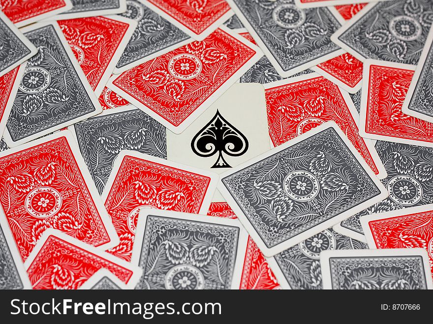 Ace of spades in the centre surrounded by red and grey playing cards