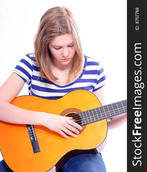 Studioshot of a young beautiful woman playing acoustic six-string guitar, isolated on white background. Studioshot of a young beautiful woman playing acoustic six-string guitar, isolated on white background