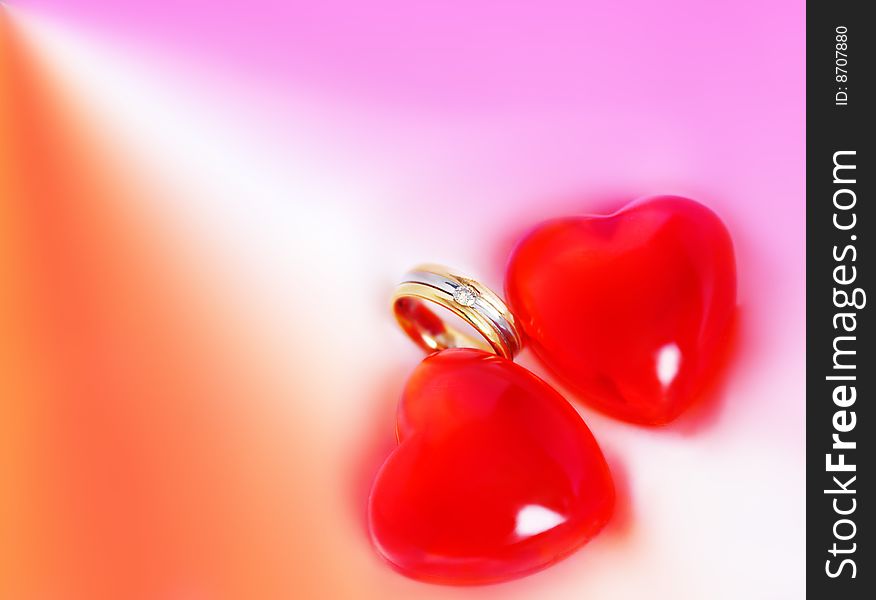 Two red hearts and diamond ring on colorful background. Two red hearts and diamond ring on colorful background