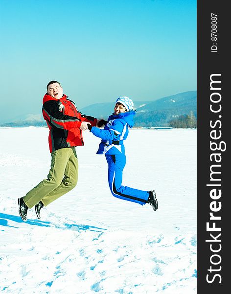 Happy young couple jumping and having fun outdoor in wintertime. Happy young couple jumping and having fun outdoor in wintertime