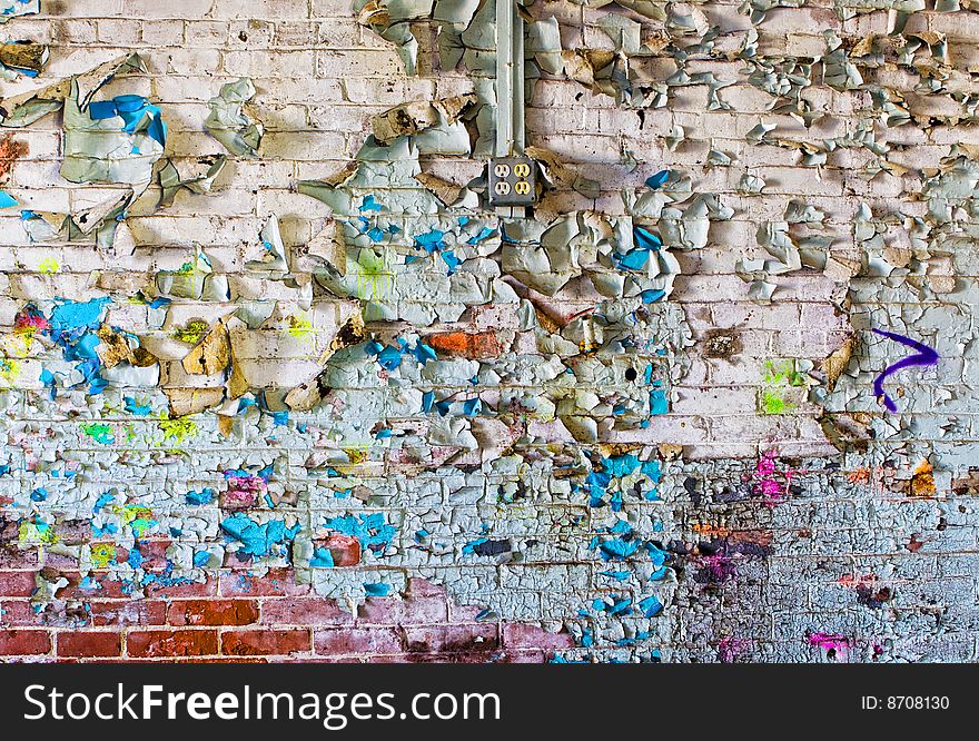 A grungy wall of peeling paint and graffiti, could also be used as a background. A grungy wall of peeling paint and graffiti, could also be used as a background