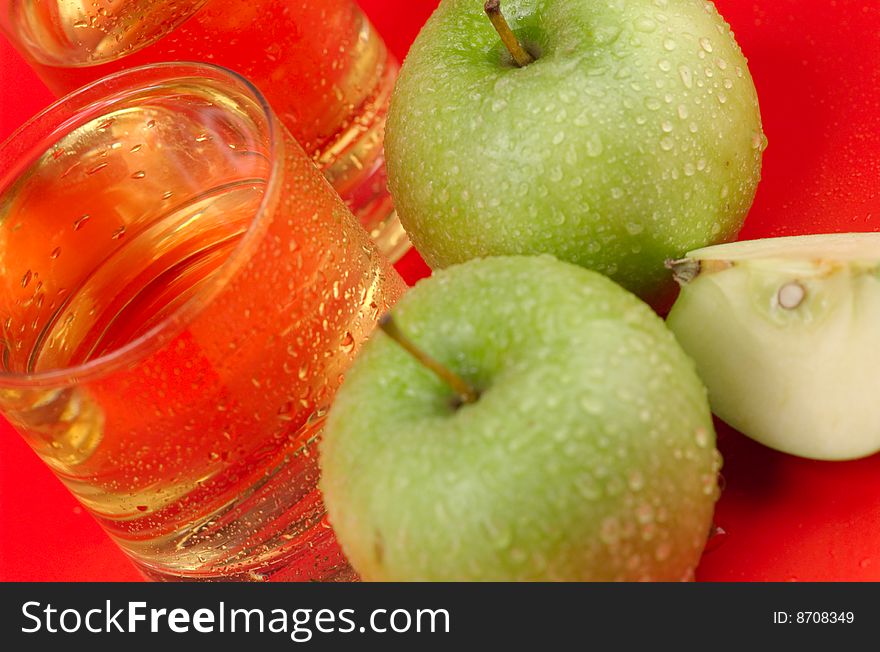 The big green apple with dewdrops on a red background. The big green apple with dewdrops on a red background