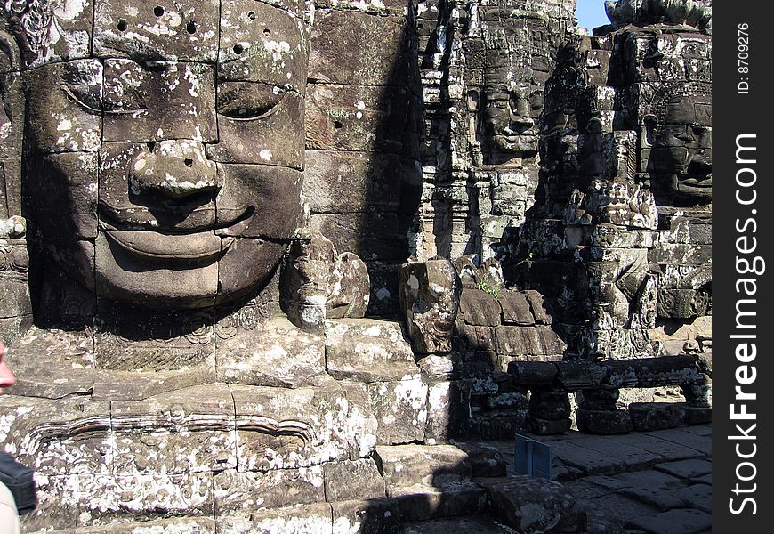 Ancient statues smile at pilgrims and tourists in Cambodia's Angkor Wat temple complex. Ancient statues smile at pilgrims and tourists in Cambodia's Angkor Wat temple complex.