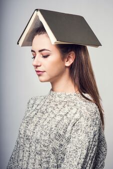 Free Girl Student Brunette In A Warm Sweater, Reading A Book And Dreaming Stock Image - 87014391