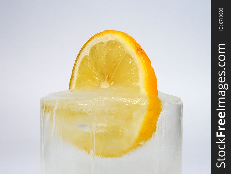 Lemon in ice on a white surface