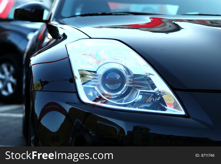 This black sports car was so shining you could see the reflections of the area. This black sports car was so shining you could see the reflections of the area.