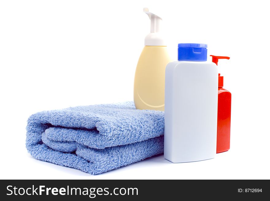 Body care products and towel on white background