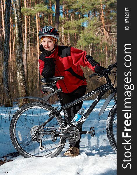 Girl with bike in the spring forest, last snow and sunny day