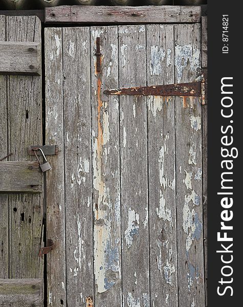 Detail of an old wooden shed locked with a padlock