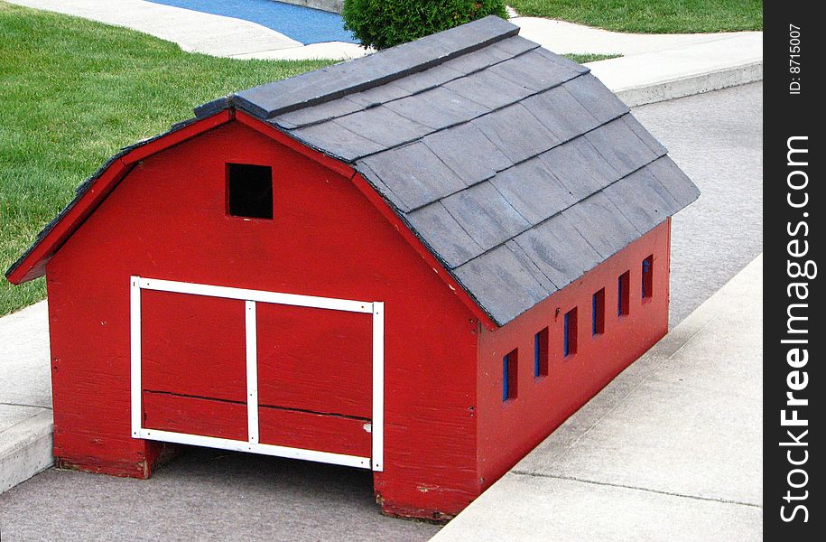 A picture of the little red barn on a miniature golf course. A picture of the little red barn on a miniature golf course.