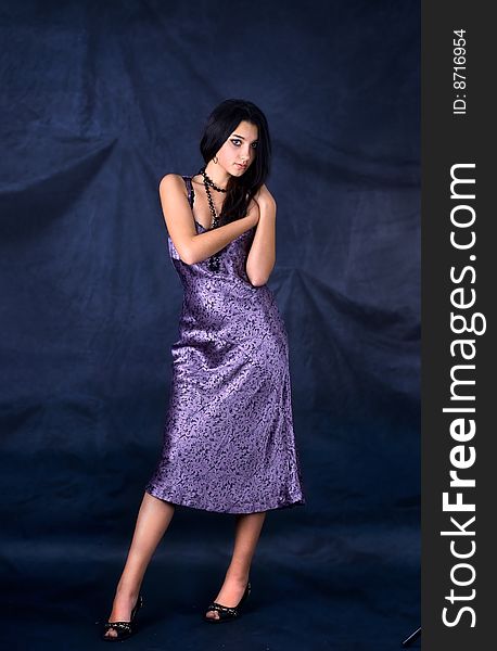 Series. Portrait of the beautiful brunette in a dark blue dress