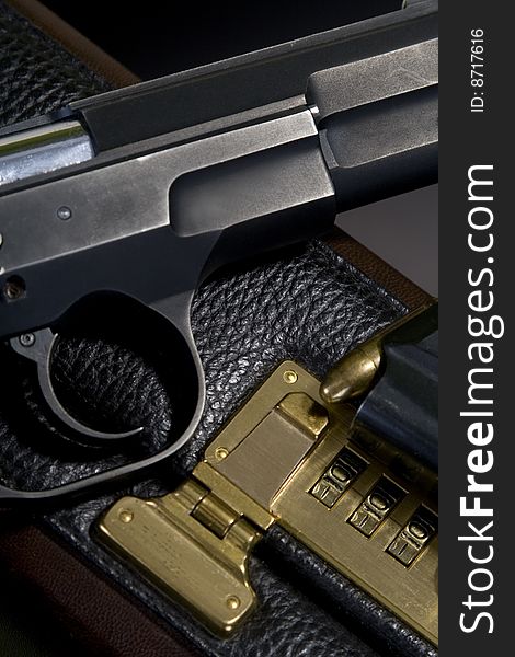 Pistol on the briefcase, black background