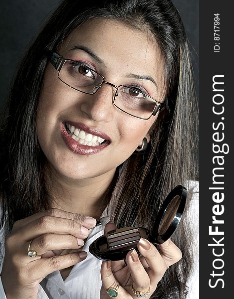 Girl applying makeup in studio.