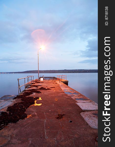 A gorgeous blue stillness with pier on lake at twilight. A gorgeous blue stillness with pier on lake at twilight