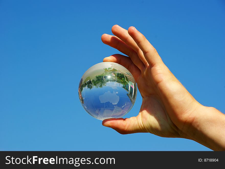 Globe in hand isplated on sky