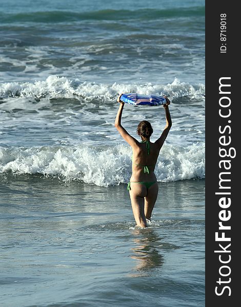 Bikini Girl with boogie board in water, waiting for the wave. Bikini Girl with boogie board in water, waiting for the wave